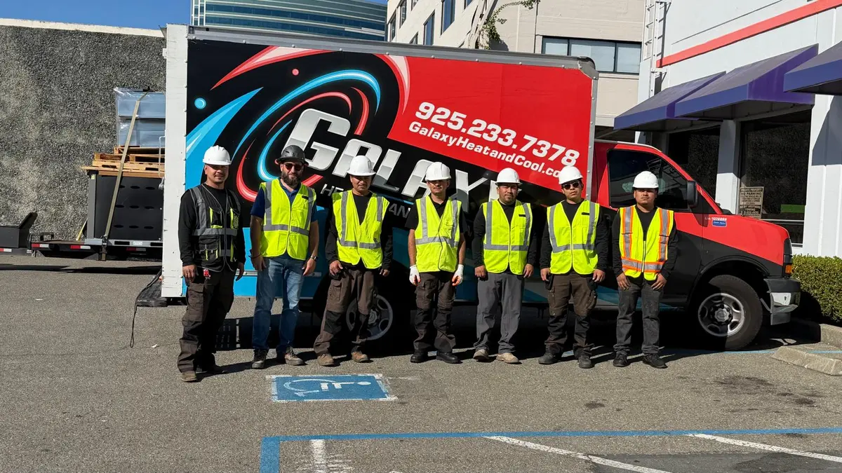 Galaxy commercial HVAC crew in hard hats and safety vests standing in front of a Galaxy service truck
