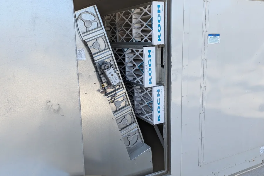 Commercial HVAC maintenance with the service panel open and replacement air filters visible